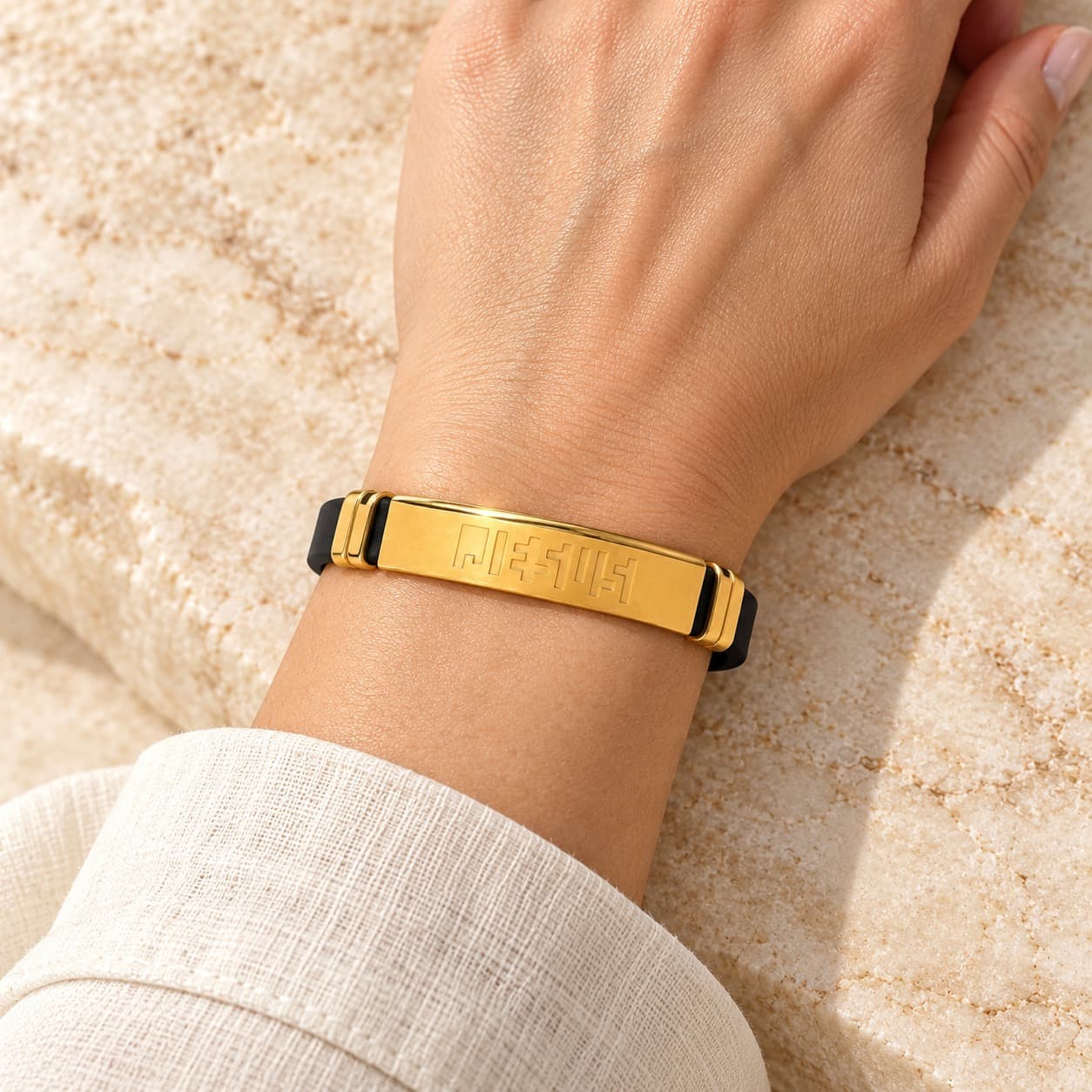 Gold bracelet worn on the wrist with a linen cuff
